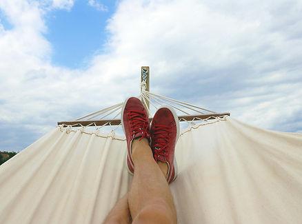 Man lying in hammock.  Image by Mateusz Dach. 