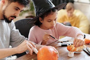 Father and daughter decorating pumpkins.  Image by Daisy Anderson.